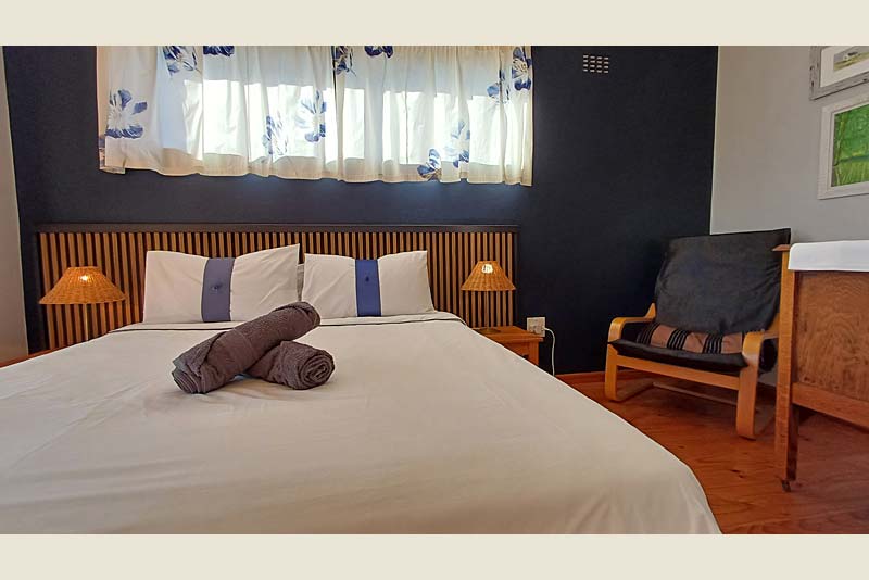 The main bedroom with balcony and queen bed. 