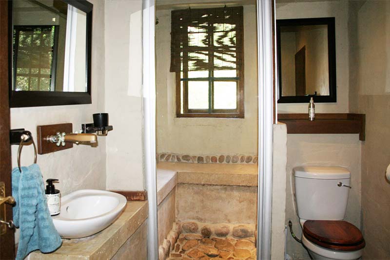 Second en-suite bathroom featuring stones underfoot.