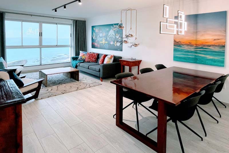 Living area and dining area with sea and mountain view.